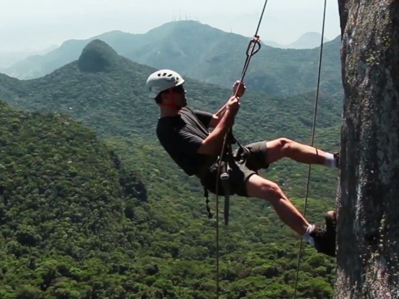 Homem fazendo rapel na pedra Bico do Papagaia no Rio de Janeiro.