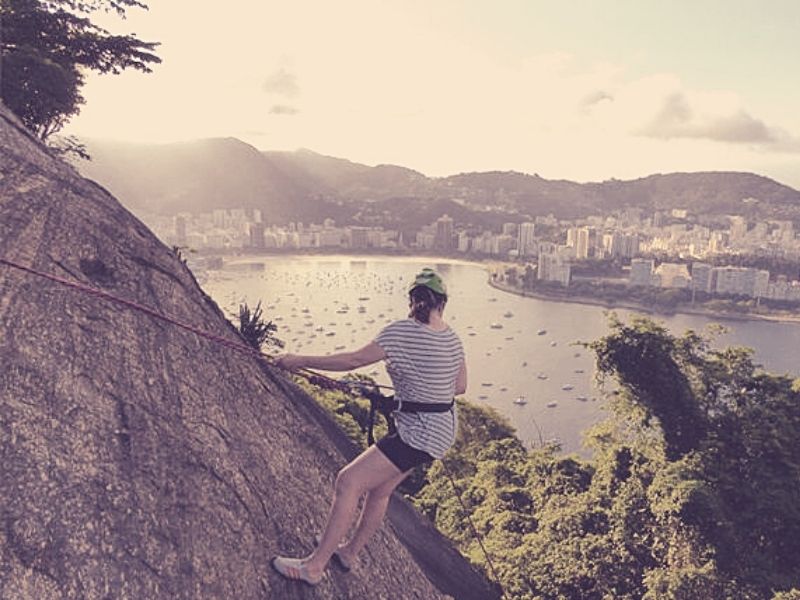 Mulher fazendo rapel no morro da Urca no Rio de Janeiro