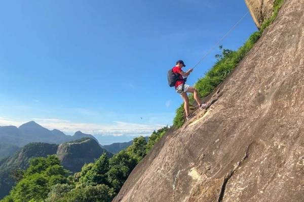 Homem fazendo rapel na pedra da Gávea.