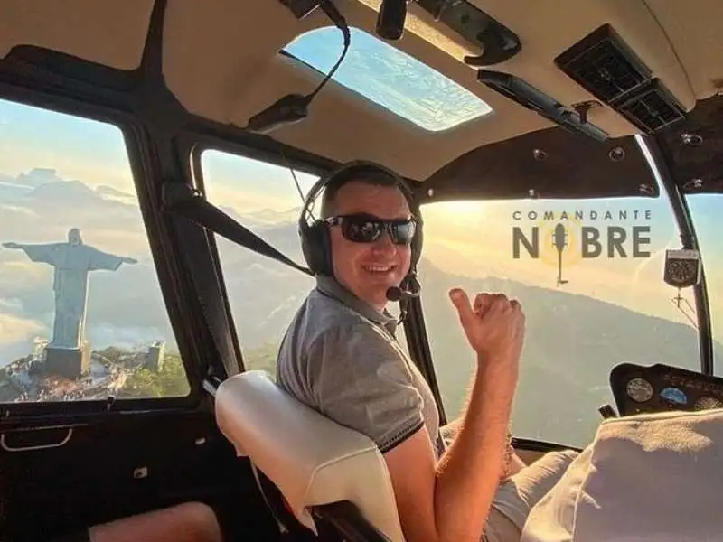 Homem voando de helicóptero no Rio de Janeiro.