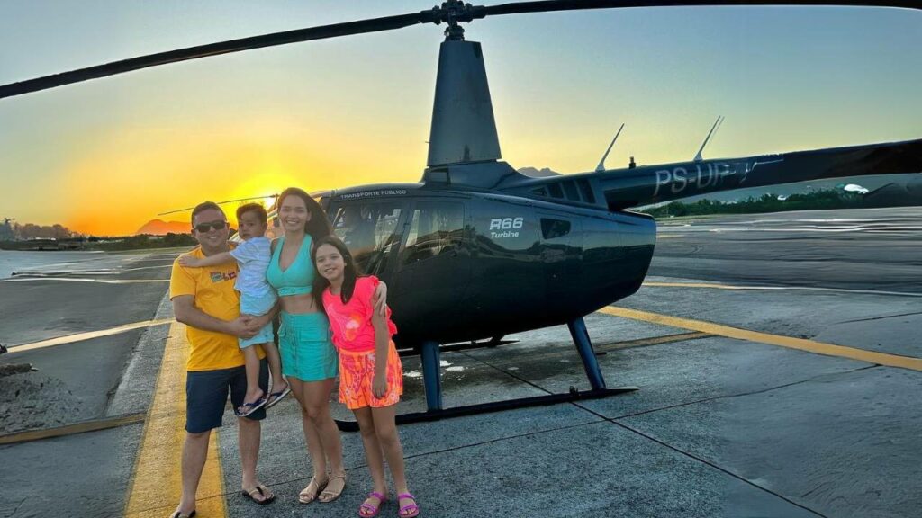 Família na frente do helicóptero.
